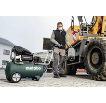 Une personne nettoie un filtre à air d'un engin de chantier avec un compresseur Metabo Basic 400-50 V.