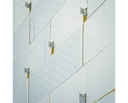 Isolation de façade avec des panneaux isolants et des pattes de fixation métalliques lors du montage sur un mur.