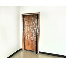 Porte anti-poussière avec fermeture à glissière pour les rénovations, montée sur un cadre de porte en bois.
