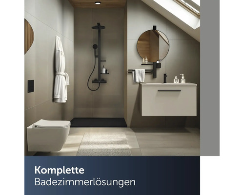 Modernes Badezimmer mit ebenerdiger Dusche, Wand-WC, Waschtisch mit Unterschrank und rundem Spiegel unter einer Dachschräge.