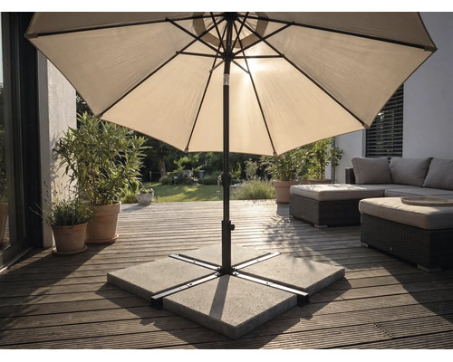 Parasol sur une terrasse en bois avec un socle en plaques de béton, des meubles de jardin et des plantes dans un espace extérieur lumineux.