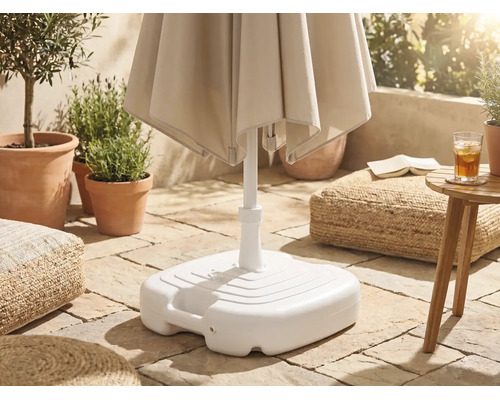 Weißer Sonnenschirmständer aus Kunststoff auf einer gepflasterten Terrasse mit Pflanzen und Sitzkissen.