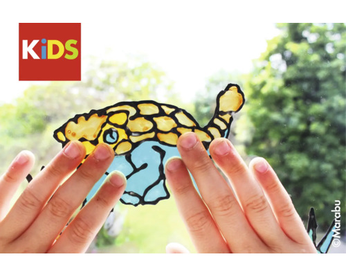 Mains d'enfant touchant un motif de poisson réalisé avec la peinture pour fenêtres Marabu KIDS sur une vitre. Logo Marabu.