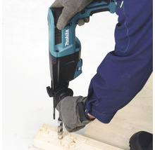 Une personne portant des gants de protection utilise un perforateur Makita pour percer un morceau de bois. Logo Makita visible.
