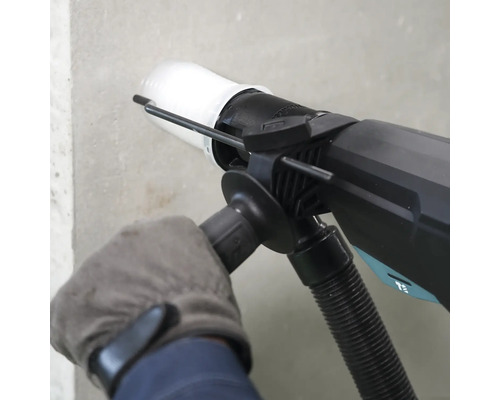 Perforateur avec kit d aspiration de poussière utilisé sur un mur.