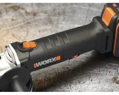 Vue rapprochée d'une meuleuse d'angle sans fil Worx avec poignée ergonomique et interrupteur à glissière sur un plan de travail.