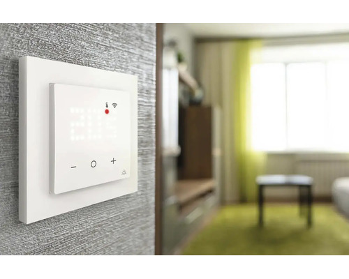 Thermostat mural intelligent avec affichage numérique de la température et connexion wifi et touches tactiles dans un salon lumineux.