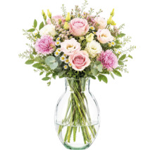 Bouquet de fleurs roses et blanches avec roses, œillets et lisianthus dans un vase en verre.