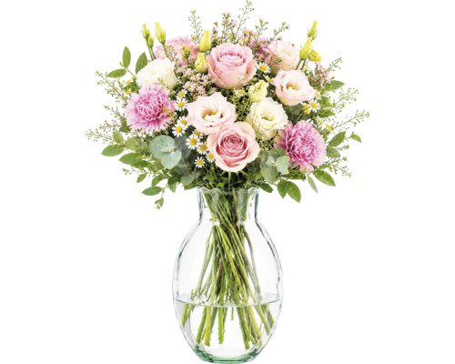 Bouquet de fleurs roses et blanches avec roses, œillets et lisianthus dans un vase en verre.