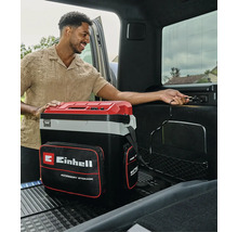 Glacière portable Einhell avec sacoche de rangement, branchée sur une prise 12 volts dans le coffre d'une voiture.