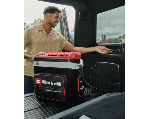 Glacière portable Einhell avec sacoche de rangement, branchée sur une prise 12 volts dans le coffre d'une voiture.