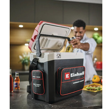 Glacière sans fil Einhell Power X-Change avec sacoches dans une cuisine, un homme retire une bouteille de la glacière ouverte.