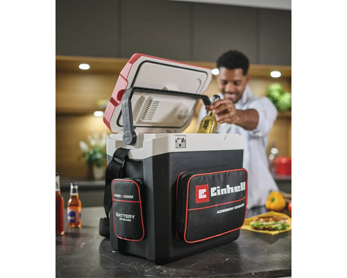 Glacière sans fil Einhell Power X-Change avec sacoches dans une cuisine, un homme retire une bouteille de la glacière ouverte.