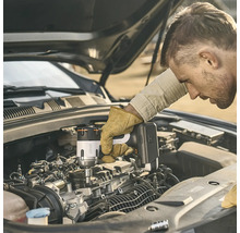 Un homme utilisant une boulonneuse à chocs sans fil Litheli pour travailler sur un moteur de voiture avec le capot ouvert.