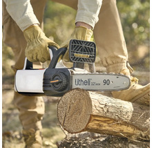 Tronçonneuse à batterie Litheli sciant un tronc d'arbre, utilisée par une personne portant des gants de travail.