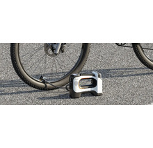 Pompe à air sans fil portable Litheli gonflant un pneu de vélo sur l'asphalte.
