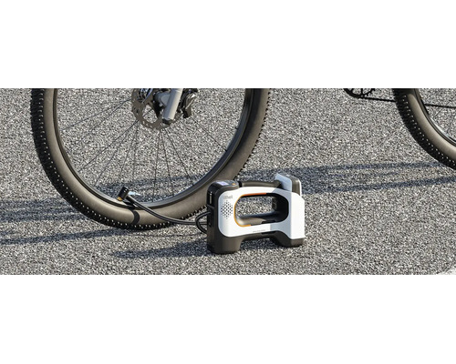 Pompe à air sans fil portable Litheli gonflant un pneu de vélo sur l'asphalte.