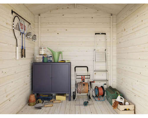 Vue intérieure d'un abri de jardin en bois, organisé avec armoire métallique, escabeau, dévidoir et outils de jardinage au sol et aux murs.