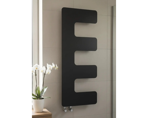 Radiateur design moderne noir en forme de peigne sur un mur carrelé clair à côté d'une orchidée blanche.