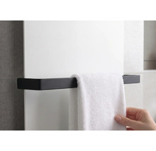 Porte-serviette noir pour radiateur, design angulaire, avec une serviette suspendue.