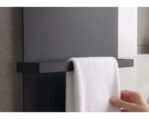 Porte-serviettes moderne noir monté sur un radiateur plat avec une serviette blanche.