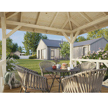 Pavillon en bois moderne avec un salon composé de chaises en corde tressée sur une terrasse en bois donnant sur un jardin et des maisons.
