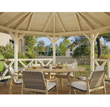 Pavillon de jardin en bois avec un ensemble composé d'une table ronde en bois et de chaises tressées dans un grand jardin lumineux.