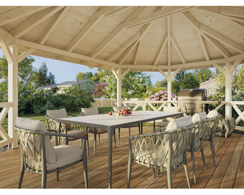 Pavillon de jardin ouvert en bois avec table et fauteuils tressés sur une terrasse en bois dans un jardin verdoyant.