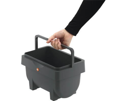 Une main tient un récipient rectangulaire en plastique avec poignée de transport Hailo.