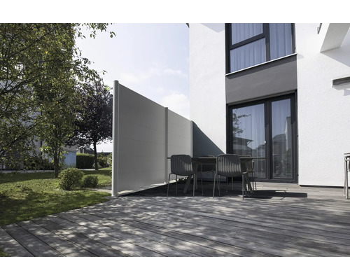 Brise-vue moderne sur une terrasse en bois avec mobilier de jardin à côté d'une maison.