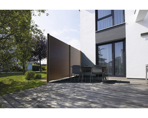 Terrasse moderne avec plancher en bois, mobilier de jardin et écran d'intimité brun composé d'éléments en WPC à côté d'un mur blanc.
