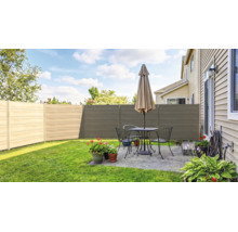 Clôture brise-vue moderne composée de panneaux horizontaux dans un jardin avec terrasse, salon de jardin et parasol sur une pelouse soignée.