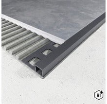 Exemple d'application d'un profilé pour carrelage carré en anthracite lors de la pose d'un carreau dans la colle. (Image AI modified or generated)