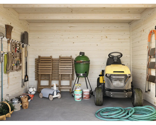 Abri de jardin en bois lumineux et organisé avec tondeuse autoportée, barbecue en céramique, chaises de jardin et outils suspendus au mur.