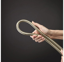 Une main tient un tuyau d installation métallique flexible ou un tube métallique pliable.