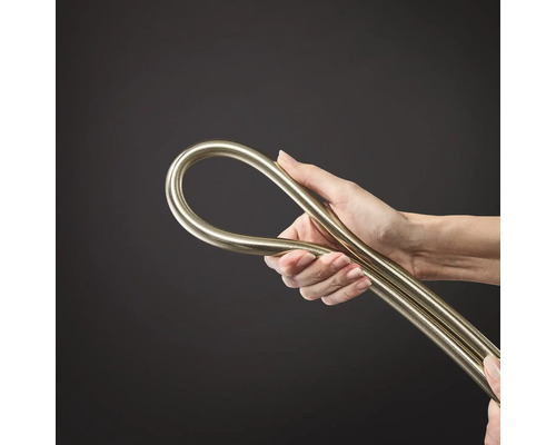 Une main tient un tuyau d installation métallique flexible ou un tube métallique pliable.