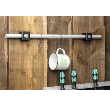 Aluminiumrohr mit zwei schwarzen Haltern an Holzwand montiert, an S-Haken hängt eine Tasse.