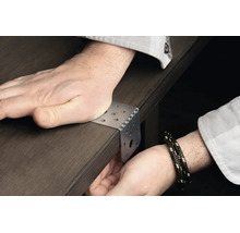 Cornière de fixation en métal sur un plateau de table, positionnée manuellement