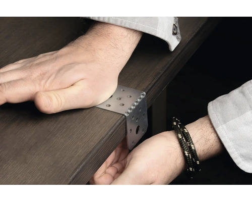 Cornière de fixation en métal sur un plateau de table, positionnée manuellement
