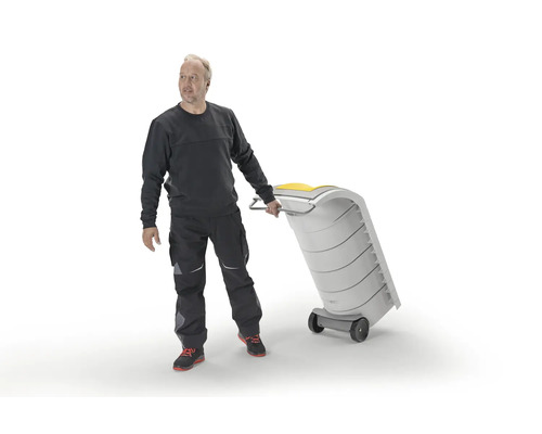 Un artisan tire une poubelle en plastique mobile sur roulettes.