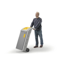 Un homme pousse un conteneur à déchets mobile ou un chariot roulant avec poignée et roues.