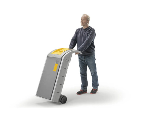 Un homme pousse un conteneur à déchets mobile ou un chariot roulant avec poignée et roues.