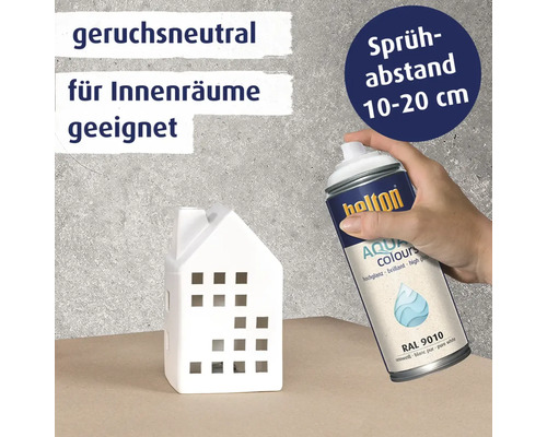 Une main tient une bombe de peinture Belton Aqua Colours pour peindre une petite maison en céramique, avec des conseils sur l'odeur et la distance.