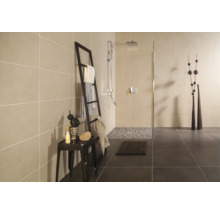 Salle de bain moderne avec douche à l'italienne, carrelage mural clair, carrelage au sol foncé et échelle décorative porte-serviettes.