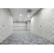 Douches communes modernes avec carrelages muraux et au sol carrés et plusieurs pommes de douche installées.