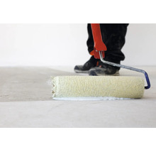 Personne appliquant une sous-couche ou de la peinture sur un sol avec un rouleau de peinture