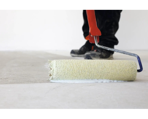 Personne appliquant une sous-couche ou de la peinture sur un sol avec un rouleau de peinture