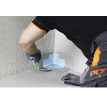 Artisan travaillant une bande d etancheite dans un angle rentrant avec une truelle pour une etancheite murale et au sol professionnelle.