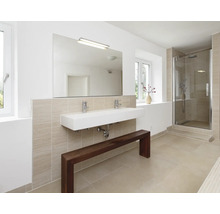 Salle de bain moderne avec double vasque, miroir mural, robinetterie, cabine de douche et un banc en bois devant un mur carrelé clair.