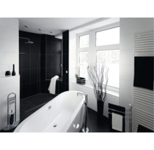 Salle de bains moderne avec baignoire îlot, douche à l'italienne, carrelages contrastés et radiateur sèche-serviettes pour une ambiance élégante.